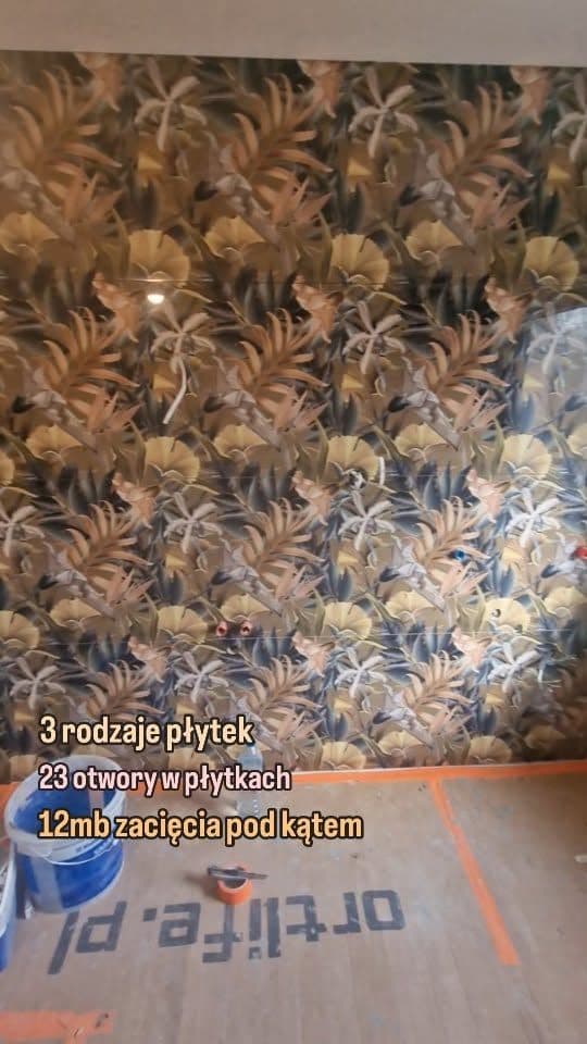 Ściana z dekoracyjnymi płytkami w tropikalny wzór liści